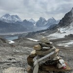 Prayer-flag-wrapped cairn at the summit of Renjo La pass (5,360 m) on the Gokyo trek, with snow-capped Khumbu peaks beyond.
