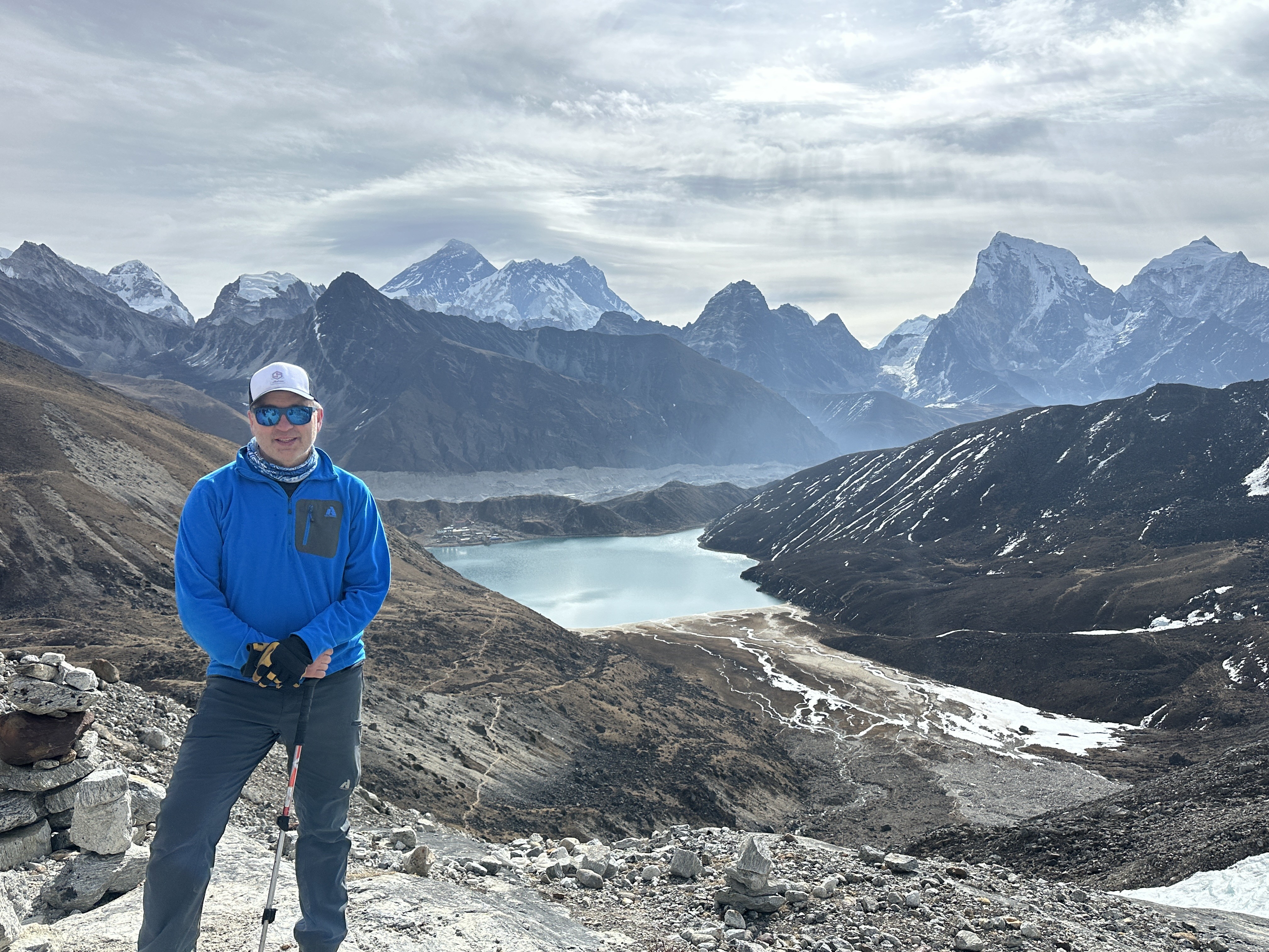 Derik standing above a Gokyo Lake with snow-capped Khumbu peaks in the background.