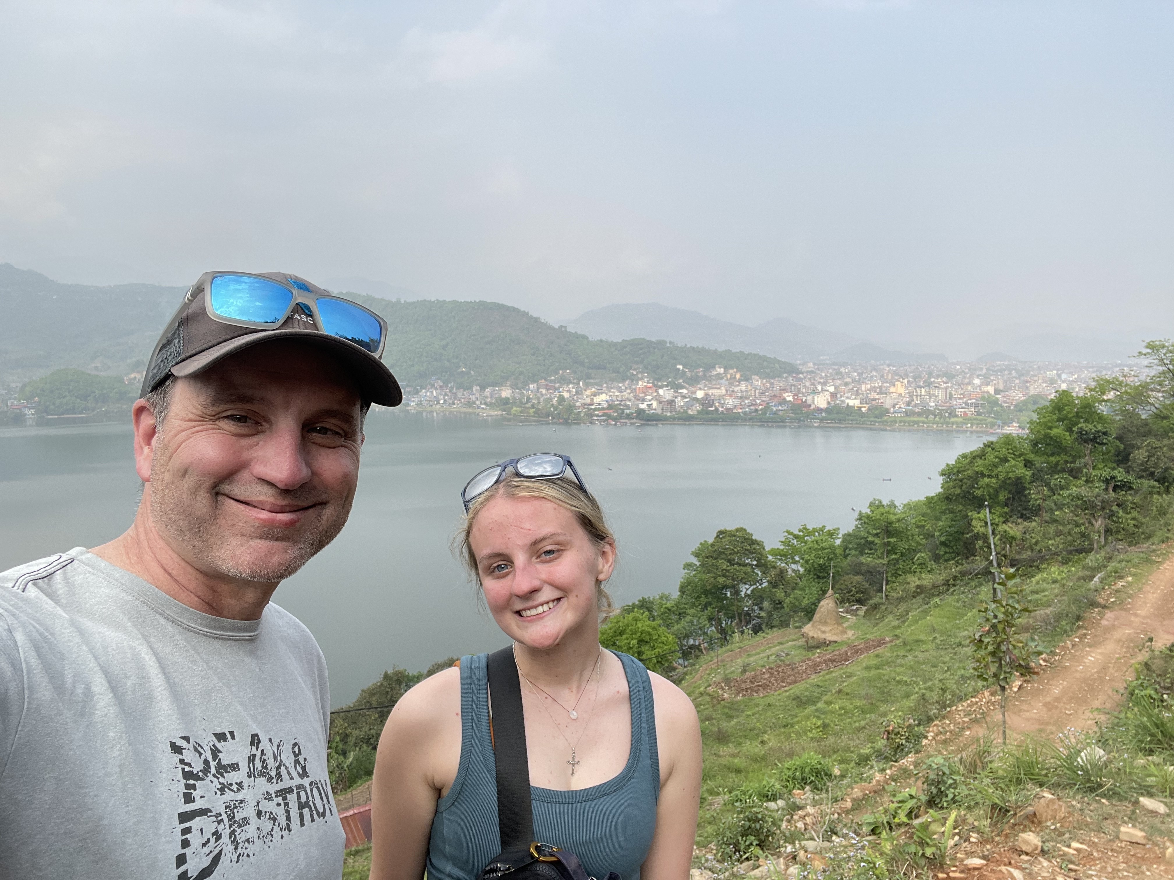 Derik and his daughter at a viewpoint overlooking Pokhara and Phewa Lake.